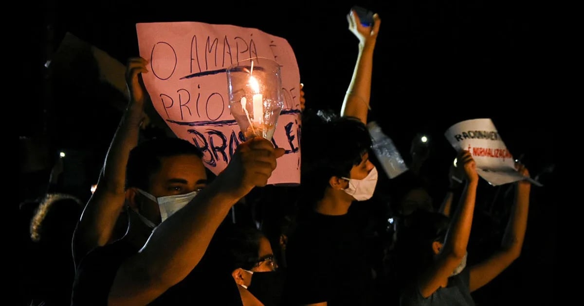 Foto mostra manifestantes com velas e cartazes por apagão em 2020 no Amapá