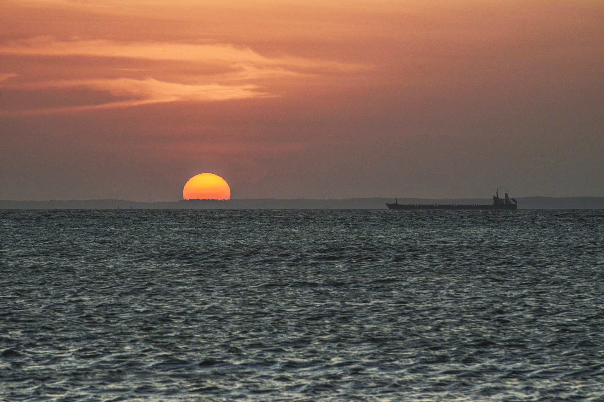 Navio no mar com pôr do sol ao fundo