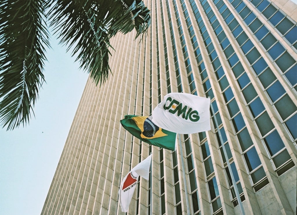 Imagem mostra o prédio da Cemig com bandeiras da empresa, Brasil e Minas Gerais.