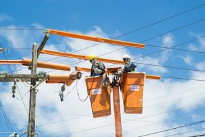 Eletricistas fazem reparo em rede de distribuição