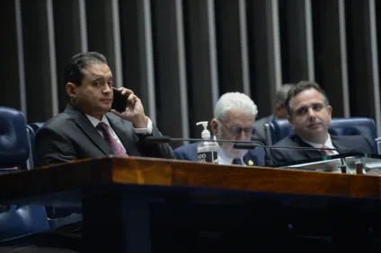 Senador Weverton (PDT-MA), relator do PL 576, fala ao telefone durante sessão deliberativa da Casa